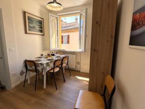 a dining room with a table with chairs and a window at La Piazzetta in Cingoli