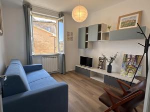 a living room with a blue couch and a tv at La Piazzetta in Cingoli