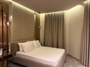 a small bedroom with a bed with white sheets at The cosy inn vlora in Vlorë