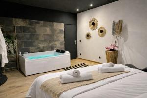 a bathroom with a large bed and a bath tub at Escale Singulière - Balnéo, patio et confort 4 étoiles in Sète