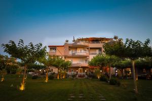 a large building with trees in front of it at Afroditi Hotel in Paralia Katerinis