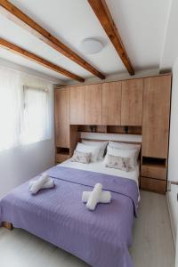 a bedroom with a purple bed with two towels on it at Lastva Nature Retreat in Mostar