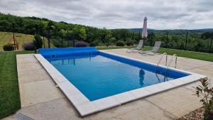 a swimming pool with two chairs in a yard at Lazarica in Divoš