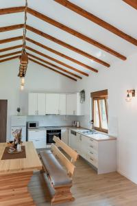 a kitchen with white cabinets and a wooden table at Lastva Nature Retreat in Mostar
