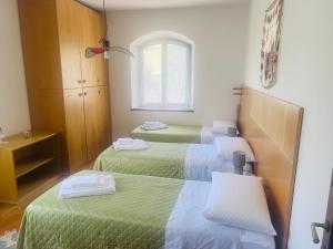 a room with three beds with green sheets and a window at Holiday al Poggettone in Monteroni dʼArbia +27 photos