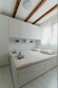 a white bedroom with a large bed with white cabinets at Lastva Nature Retreat in Mostar