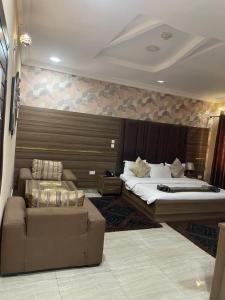 ein Hotelzimmer mit zwei Betten und einer Couch in der Unterkunft Fawzy Hotel in Ibadan + 60 Fotos