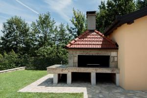 a stone fireplace with a red tile roof at Lastva Nature Retreat in Mostar +59 photos