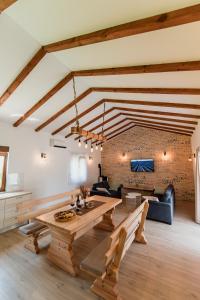 a living room with a wooden table and a brick wall at Lastva Nature Retreat in Mostar
