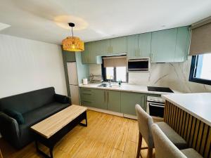 a kitchen with green cabinets and a couch and a table at Casa Cazorla in Ojén
