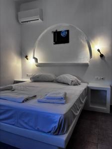 a bed with two towels on it in a room at Kapetan Sorokos Studios 2 in Koufonisia