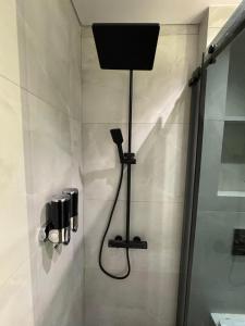 a bathroom with a shower with a speaker on the wall at EmberHaus Retreat with Private Pool in Kafr ‘Ubaydā +13 photos