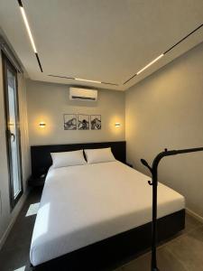 a bedroom with a white bed in a room at EmberHaus Retreat with Private Pool in Kafr ‘Ubaydā