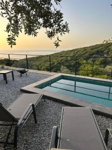 a swimming pool with a view of the ocean at EmberHaus Retreat with Private Pool in Kafr ‘Ubaydā
