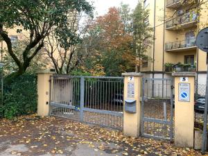 a gate in front of a building with leaves on the ground at Spacious Apartment 20min from Piazza Maggiore in Bologna