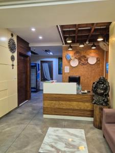 a lobby of a restaurant with a counter with hats on the wall at Hotel Clover in Zirakpur
