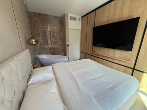 a bedroom with a bed and a tv and a tub at Apartament - VIDOK 109 in Olsztyn