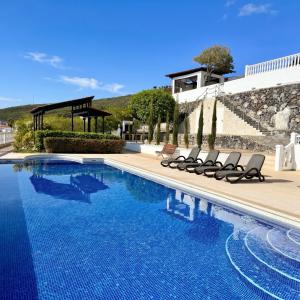 a swimming pool with lounge chairs next to a house at Villa Tequila in Adeje