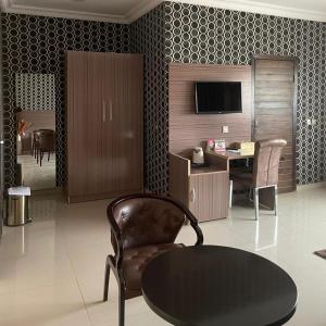 ein Wohnzimmer mit einem Tisch und einem Stuhl in der Unterkunft Fawzy Hotel in Ibadan