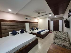 a hotel room with two beds and a chair at Hotel Clover in Zirakpur +49 photos