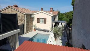a villa with a swimming pool in front of a house at Villa Nostalgia - with private heated pool, jacuzzi and sauna in Koper