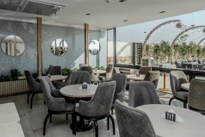 a restaurant with tables and chairs and windows at Hotel Comfort Giza in Cairo