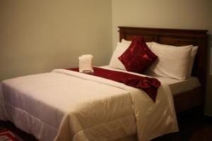 a bedroom with a bed with red and white pillows at G Villa Executive Hotel in Dodoma