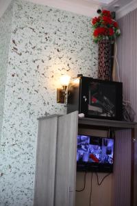 a room with a tv and a wall with flowers at G Villa Executive Hotel in Dodoma
