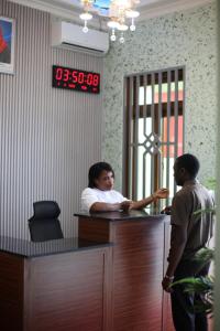 a woman is standing at a desk in an office at G Villa Executive Hotel in Dodoma