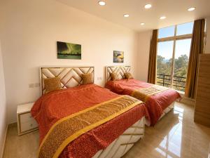 a bedroom with two beds and a large window at Eva & Era Paradise in Solan