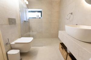 a bathroom with a toilet and a sink and a shower at Archontiko Koufantonis in Kotronas +23 photos