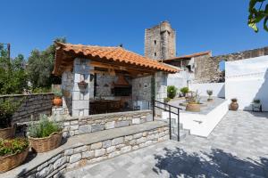a stone house with a pizza oven in a courtyard at Archontiko Koufantonis in Kotronas