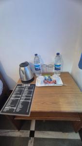 a table with two bottles of water and a plate of food at Secret kitchen rooms in Candolim +14 photos