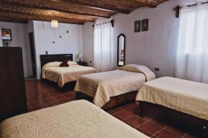 a room with three beds in a room at Casa Manzanos in Guanajuato