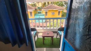 a view of a balcony with a stool on the grass at Secret kitchen rooms in Candolim