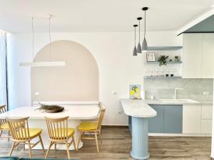 a kitchen and dining room with a white table and chairs at Sea't La Vie Villas in Hamallë
