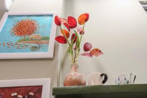 a vase with flowers in it sitting on a shelf at Bống's Homestay and Cafe in Ho Chi Minh City +4 photos