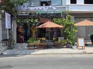 a restaurant with tables and umbrellas in front of it at Bống's Homestay and Cafe in Ho Chi Minh City