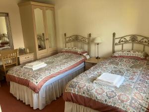 a bedroom with two beds and a mirror at Ardmuir in Turriff