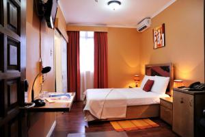 a hotel room with a bed and a window at Culture Crossroads Inn in Port-of-Spain
