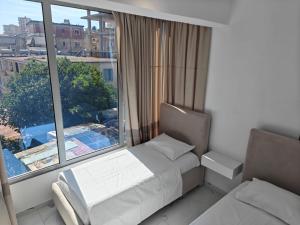 a bedroom with a bed and a large window at Hotel Elisabet in Sarandë