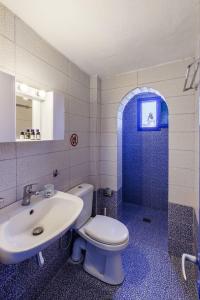 a bathroom with a white toilet and a sink at Stamatis Rooms in Skopelos Town +50 photos