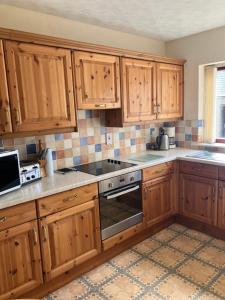 a kitchen with wooden cabinets and a stove top oven at Ardmuir in Turriff