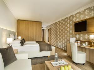 a hotel room with a bed and a tv at Small & Beautiful Hotel Gnaid in Tirolo