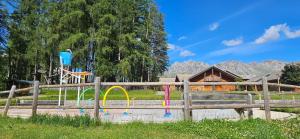 a wooden fence with a playground in a park at Studio lumineux et cosy avec vue montagne 7è étage in Superdevoluy
