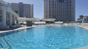 a large swimming pool with people in the water at Paraiso Studio in Playa Paraiso