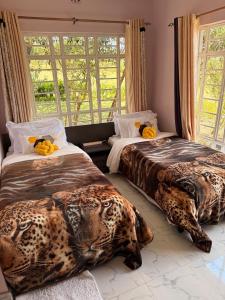two beds in a room with animals on them at OlTepesi HomeStay in Ololaimutiek