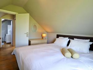 a bedroom with a large white bed with white pillows at Cocoon in Houffalize