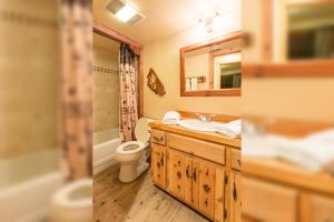 two pictures of a bathroom with a toilet and a sink at Arrowhead Pine Rose Cabins in Twin Peaks
