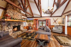 a living room with couches and a stone fireplace at Arrowhead Pine Rose Cabins in Twin Peaks